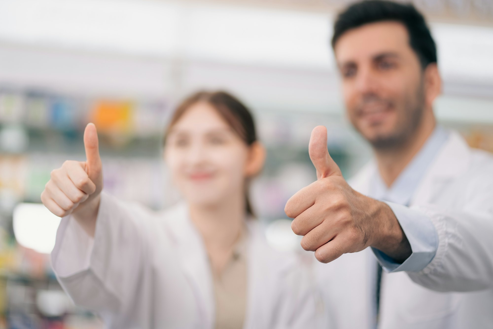 Two pharmacists showing thumb ups for guarantee the service