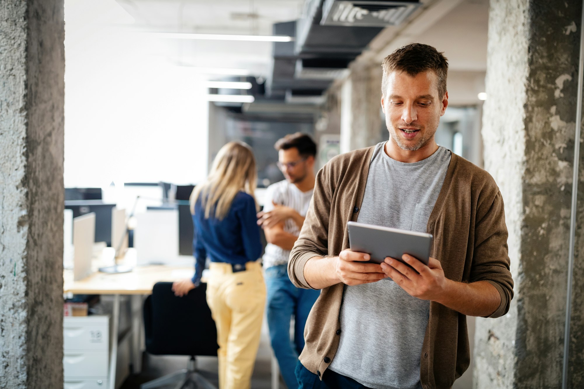 Young man using technology, digital tablet in corporate business office